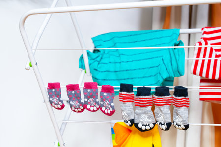 Small bright dog socks, striped T-shirts hanging on dryer after washing Wet clothes, stylish look...
