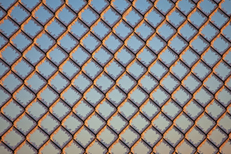 a metal fence in winter covered with ice crystals and sunlight