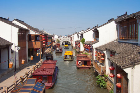 a canal with boats in the old town of suzhou and sunny blue skyの写真素材