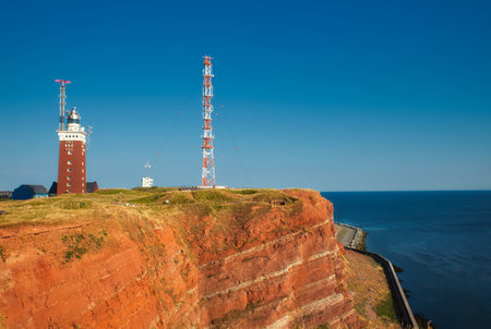 lighthouse and transmission mast on Heligoland with blue sky and seaの写真素材