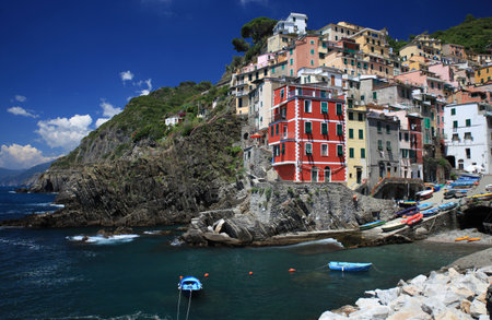 Riomaggiore a village of the Cinque Terre on the Ligurian coast with its colorful houses and boats on the Mediterranean seaの写真素材