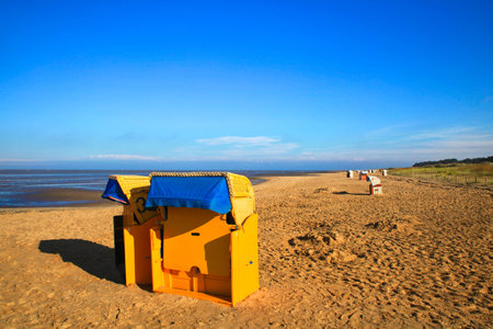 Beach chairs on an empty beach at sunny blue skyの写真素材