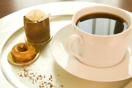 freshly brewed coffee and chocolate mousse cake on a silver trayの写真素材