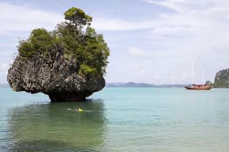 Male snorkeling in a bay with a boat in the backgroundの写真素材