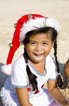Thai girl with Christmas hat playing on beachの写真素材