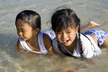 Twp little Thai children playing in the seaの写真素材