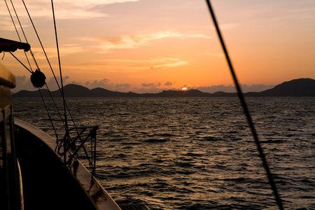 Sunset from a wooden yacht  sailing on the oceanの写真素材