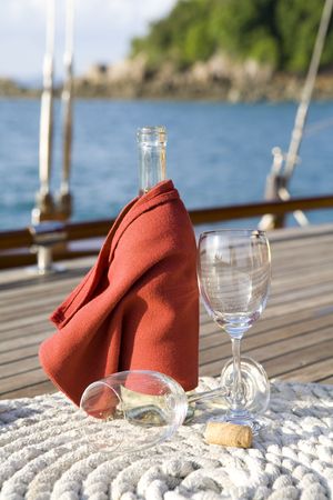 A bottle of wine on the wooden deck of a yachtの写真素材