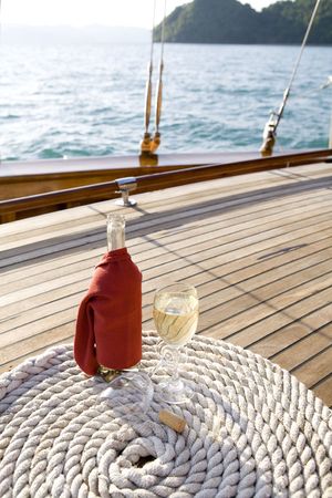 A bottle of wine on a yacht's wooden deckの写真素材