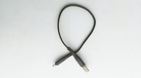 Black USB cable on a white background. Close-up. View from above.