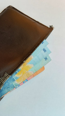 Banknotes in a leather wallet isolated on a white background.