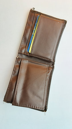 Brown leather wallet with credit card on white background, closeup of photo