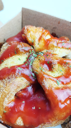 baked bread with tomato sauce and thyme in a cardboard box