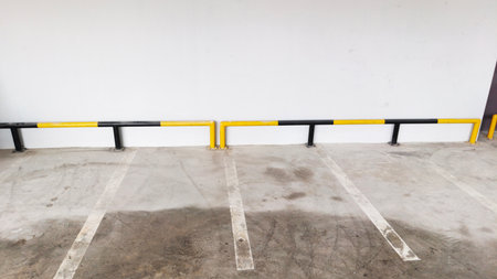 Empty parking lot with yellow barrier and white wall background, stock photoの写真素材