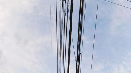 Electricity post with blue sky and white cloud background.