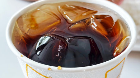 Iced coffee in a paper cup on a white background. Close up.