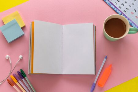Notebook with to-do-list mockup, coffee mug, pens and sticky notes on trendy pink and yellow...
