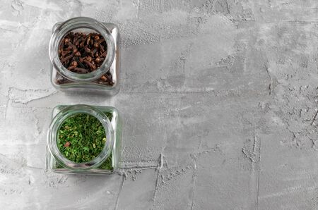 Parsley and clove in glass jar for spicy on gray concreteの写真素材