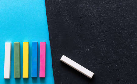 pieces of chalk on the blackboard and blue backgroundの写真素材