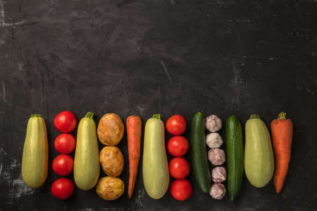 Fresh organic vegetables on the black background in flat lay designの写真素材