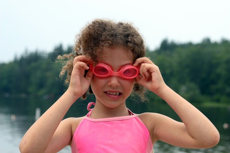 The girl in swimming glasses on a background of the natureの写真素材