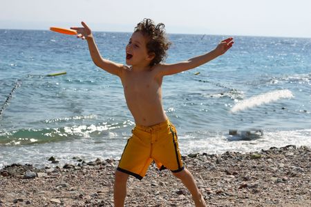 The boy on a beach start frisbeeの写真素材