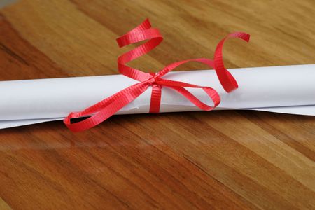 scroll with red ribbon on wood backgroundの写真素材