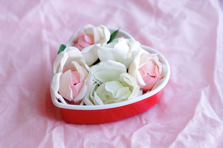 Pink and white roses in the form of heart on pink background