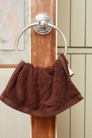 Brown towel on a hanger in a bathroomの写真素材