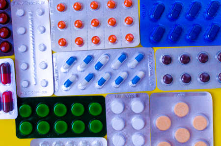 blisters of colored pills close background