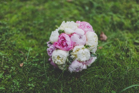 Wedding bouquet of peonies on the grassの写真素材