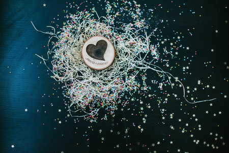 Wooden heart in the straw and confettiの写真素材