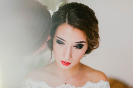 Bride whispers in the ear of girlfriendの写真素材