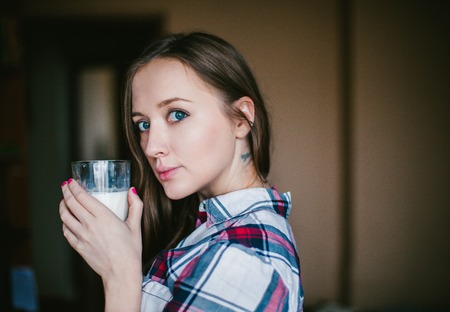 A girl holds a glass of milkの写真素材