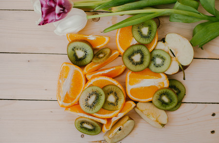 Orange slices and Kiwi fruit on wood background