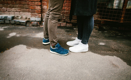 Feet in sneakers stand opposite each otherの写真素材