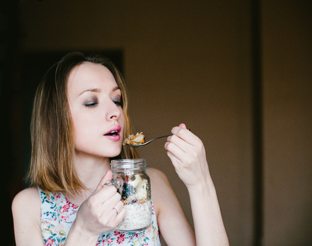 Girl eating muesli out of Cup. Foodの写真素材