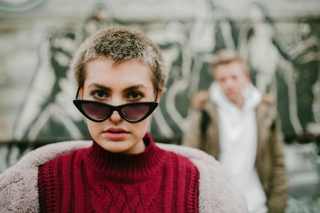 Girl with short hair in black sunglasses on the street