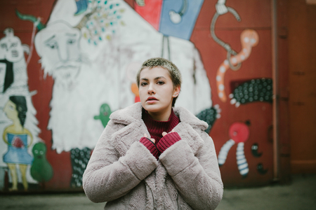 young girl with short hair and short coat on the streetの写真素材