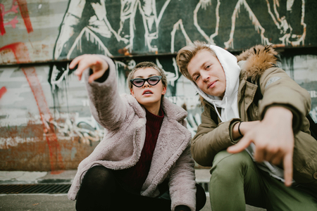 girl and Guy teens show gestures on the street