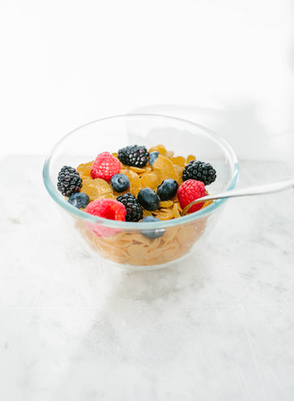 Granola, cereal with berries in the plate on light background