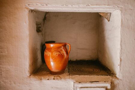 Old clay pot on a white oven