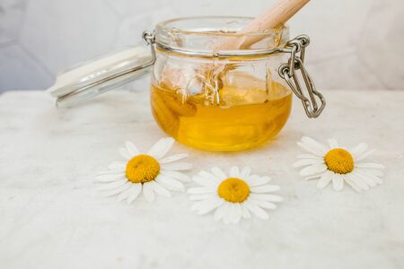 jar of honey with a wooden spoon for honey on a light background, sweetの写真素材