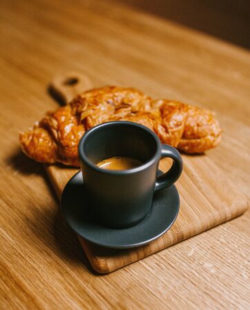 Creamy croissant and espresso cup on a wooden background, foodの写真素材