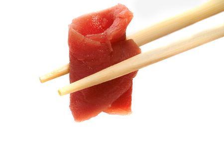 A piece of salmon fish meat in chopsticksの写真素材