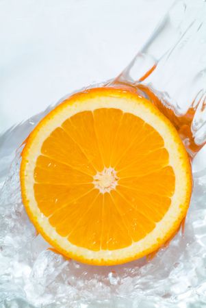 Fresh orange jumping into water with a splashの写真素材