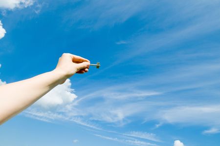 hand holding keys,blue skies in the backgroundの写真素材