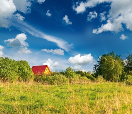 Summer landscape with green grass, road and cloudsの写真素材