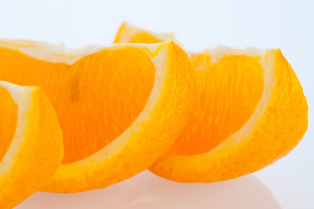 Fresh segments of an orange on a white background