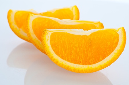 Fresh segments of an orange on a white backgroundの写真素材
